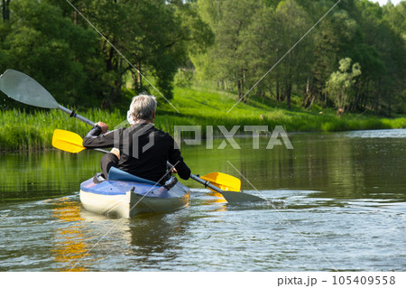 Family kayak trip for seigneur and senora. An elderly married couple rowing a boat on the river, a water hike, a summer adventure. Age-related sports, mental youth and health, tourism, active old age 105409558
