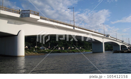夏の穏やかな日本海と青空と白い雲と海に架かる真白な夕日ライン橋 105412158