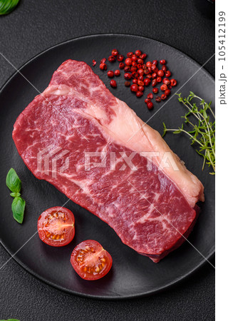 Fresh raw beef striploin steak with salt, spices and herbs 105412199