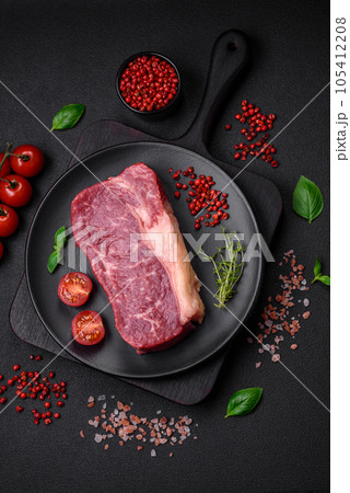 Fresh raw beef striploin steak with salt, spices and herbs 105412208