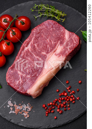Fresh raw beef striploin steak with salt, spices and herbs 105412260