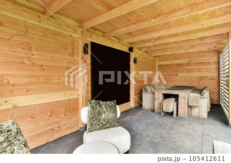 a living room with wood paneled walls and white furniture on the floor, in front of a blackboard wall 105412611