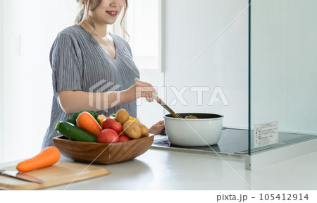 キッチンでカレーを作るアジア人女性・妊婦・プレママ キッチンでカレーを作るアジア人女性・妊婦・プレママ 105412914