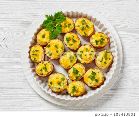 baked stuffed red potato on white baking dish baked stuffed red potato on white baking dish 105413901