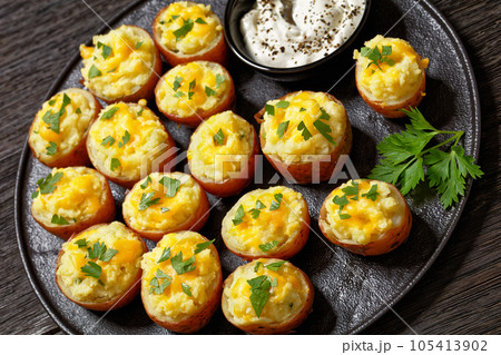 baked stuffed red potatoes on black plate 105413902
