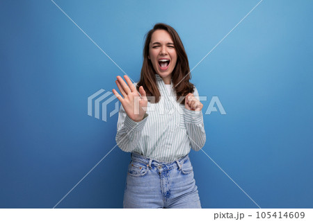 25 year old brown-haired female person laughing out loud on a blue background 105414609