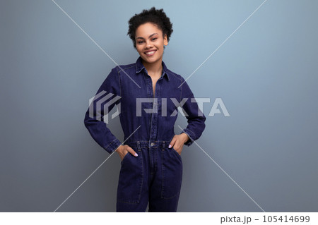 a young woman with dark skin and black hair is dressed in a blue genim suit a young woman with dark skin and black hair is dressed in a blue genim suit 105414699