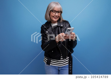 smart 60s modern middle-aged woman grandmother with gray hair makes an order on the Internet using a smart 60s modern middle-aged woman grandmother with gray hair makes an order on the Internet using a 105414789