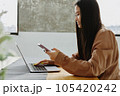 Young asian woman using smartphone and laptop at home. 105420242