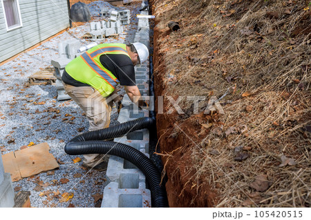 Laying drainage pipe for rainwater in retaining wall is essential to prevent water buildup. 105420515