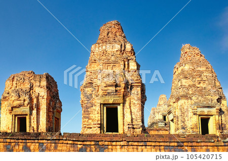 High-resolution image capturing the three monumental brick towers of the Pre Rup temple, standing proudly under the cloudless blue sky, reflecting Khmer architectural style. High-resolution image capturing the three monumental brick towers of the Pre Rup temple, standing proudly under the cloudless blue sky, reflecting Khmer architectural style. 105420715