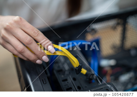 Close-up of a woman's hand holding computer cables Close-up of a woman's hand holding computer cables 105420877