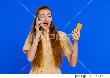 Irritated stressed business woman talking on two mobile phones having conversation conflict quarrel 105421307