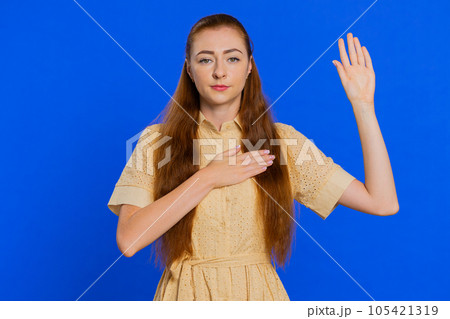 Woman raising hand to take oath, promising to be honest and to tell truth, keeping hand on chest Woman raising hand to take oath, promising to be honest and to tell truth, keeping hand on chest 105421319