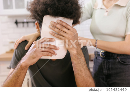African American man covers his face with electricity bills. couple are paying rent bills. 105422449