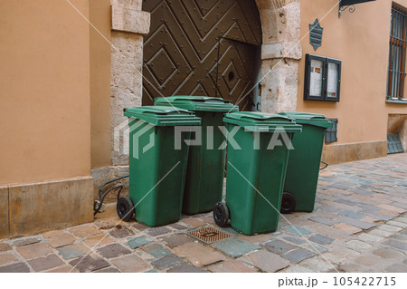 Rows of garbage cans of different colors in an alley in the city center, near a city cafe or restaurant 105422715