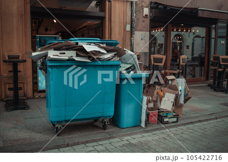Rows of garbage cans of different colors in an alley in the city center, near a city cafe or restaurant 105422716