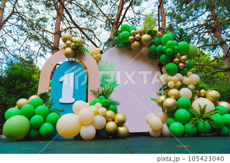 Photo zone in the park at a birthday party - green balloons with the number 1. 105423040