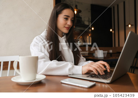 Young blogger working with laptop in cafe 105423439
