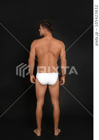 Man in underwear on black background, back view Man in underwear on black background, back view 105423632