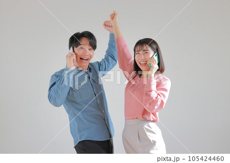 吉報に伸びあがってガッツポーズのオフィスカジュアルの男女_1 吉報に伸びあがってガッツポーズのオフィスカジュアルの男女_1 105424460