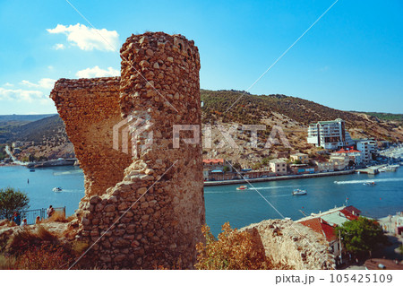 an ancient stone tower on a blue sky background 105425109