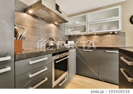 a modern kitchen with black counter tops and white trim on the cabinets in this photo is taken from an angle 105426538
