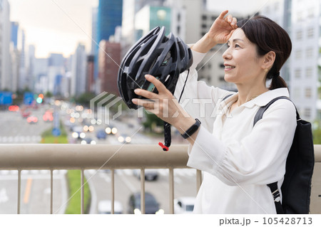 髪を気にしながら、自転車用ヘルメットを被るアラフィフ女性 髪を気にしながら、自転車用ヘルメットを被るアラフィフ女性 105428713
