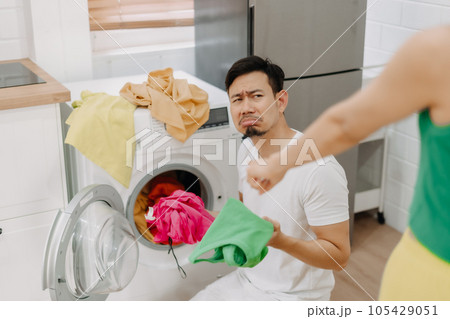 Funny crying face reaction of husband being forced to wash clothes by wife. Funny crying face reaction of husband being forced to wash clothes by wife. 105429051