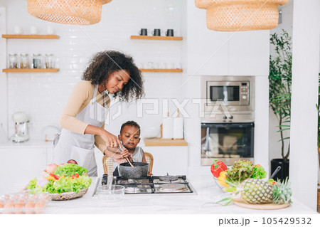 happy african black young mother with her boy lovely cute cooking together at home holiday activity happy african black young mother with her boy lovely cute cooking together at home holiday activity 105429532