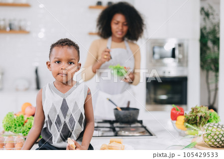 happy african black young mother with her boy lovely cute cooking together at home holiday activity happy african black young mother with her boy lovely cute cooking together at home holiday activity 105429533