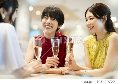 女子会イメージ シャンパングラスを持って談笑する若い女性たち 女子会イメージ シャンパングラスを持って談笑する若い女性たち 105429727