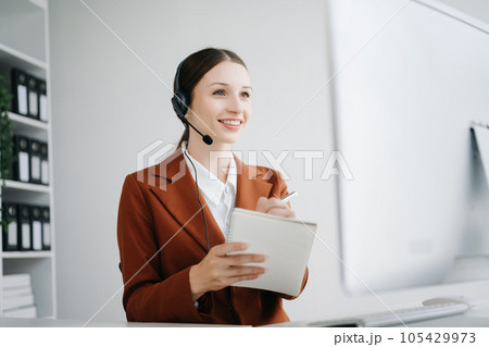 Serious call center operator in wireless headset talking with customer, woman in headphones with microphone consulting client on phone in customer support service in office center.. 105429973