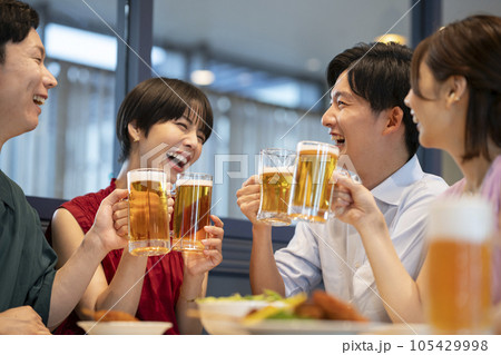 ビールジョッキを飲みながら談笑する若い男女　撮影協力：Creadisce（丸善雄松堂株式会社） 105429998