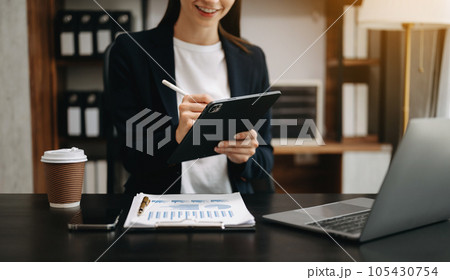 Confident businesswoman working on laptop,tablet and smartphone at her workplace at office.. 105430754