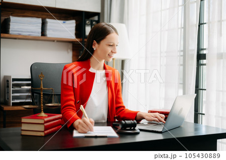 justice and law concept. Female judge in a courtroom the gavel, working with smart phone and laptop and digital tablet computer on black table justice and law concept. Female judge in a courtroom the gavel, working with smart phone and laptop and digital tablet computer on black table 105430889