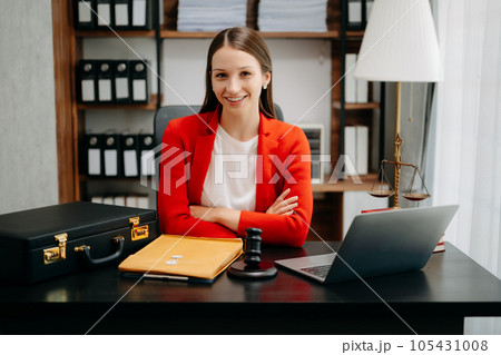 justice and law concept. Female judge in a courtroom the gavel, working with smart phone and laptop and digital tablet computer on black table justice and law concept. Female judge in a courtroom the gavel, working with smart phone and laptop and digital tablet computer on black table 105431008