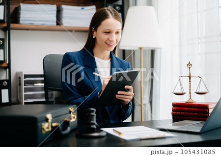 justice and law concept. Female judge in a courtroom the gavel, working with smart phone and laptop and digital tablet computer on black table justice and law concept. Female judge in a courtroom the gavel, working with smart phone and laptop and digital tablet computer on black table 105431085