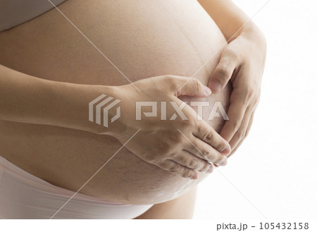 妊娠線と正中線があるお腹に手をあてる臨月の女性 妊娠線と正中線があるお腹に手をあてる臨月の女性 105432158