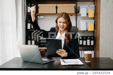 Asian business woman are delighted and happy with the work they do on their tablet, laptop and taking notes at office.. 105432524