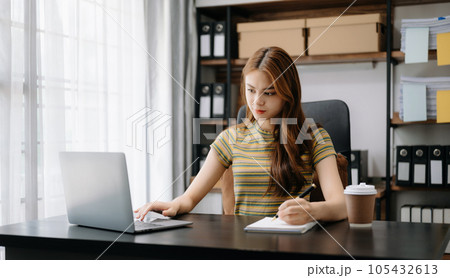 Beautiful Asian business woman typing laptop and tablet Placed at the table at home office.. 105432613