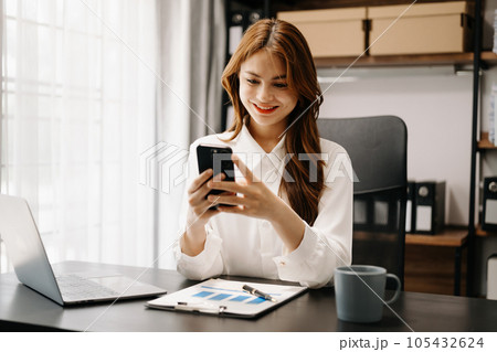 Confident business expert attractive smiling young woman holding digital tablet  on desk in creative office. 105432624