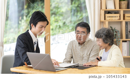 訪問営業と話しをするシニア夫婦 訪問営業と話しをするシニア夫婦 105433143