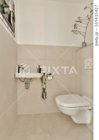 a bathroom with a toilet and flowers on the wall next to the toilet in the photo is taken from above 105435427