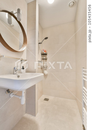 a bathroom with a sink, mirror and towel rack on the wall above it is a white tiled shower stall a bathroom with a sink, mirror and towel rack on the wall above it is a white tiled shower stall 105435456