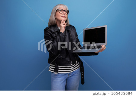 smart modern 60s mature old business lady with gray hair demonstrates laptop ownership with mockup smart modern 60s mature old business lady with gray hair demonstrates laptop ownership with mockup 105435694
