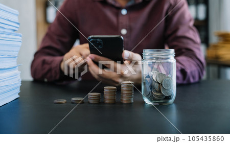 accountant working on desk in office using calculator and laptop to calculate budget. concept finance and accounting in morning light. 105435860