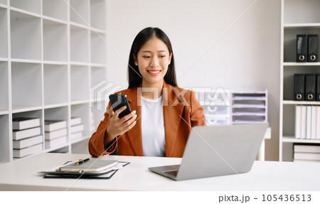 Successful Asian Businesswoman Analyzing Finance on Tablet and Laptop at Office Desk tax, report, accounting, statistics, and analytical research concept. Successful Asian Businesswoman Analyzing Finance on Tablet and Laptop at Office Desk tax, report, accounting, statistics, and analytical research concept. 105436513