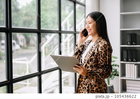 Happy asian business woman have the joy of talking on the smartphone, tablet and laptopon the office Happy asian business woman have the joy of talking on the smartphone, tablet and laptopon the office 105436622