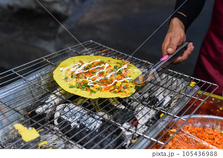 Grilled vietnamese pancake with eggs, sausages and sauces in vietnamese night market in food festival Grilled vietnamese pancake with eggs, sausages and sauces in vietnamese night market in food festival 105436988